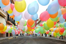 Colorful balloons floating in a street.