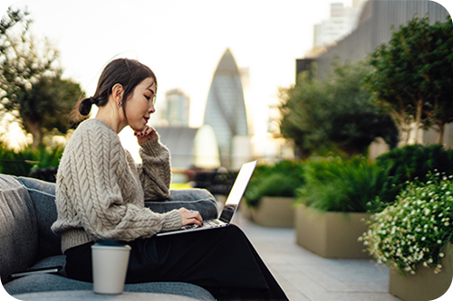 woman on laptop on rooftop in city