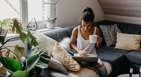 a woman drinking coffee on a couch