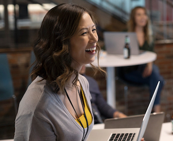 woman laughing by computer